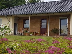 een stenen huis met een gazon en bloemen bij Ferienwohnung Hof Theensen in Bad Münder am Deister