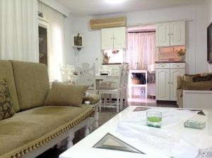 a living room with a couch and a table at Villa Fofo - Beautiful Sea Front Villa with 650m2 garden in Nea Kalikratia