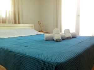 a blue bed with white pillows on top of it at Villa Fofo - Beautiful Sea Front Villa with 650m2 garden in Nea Kalikratia