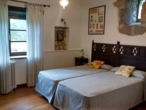 sypialnia z łóżkiem z niebieskimi prześcieradłami i oknem w obiekcie Hotel Rural Natxiondo w mieście Lekeitio +25 zdjęć