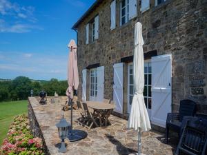 two umbrellas and a table outside of a building at Superb holiday home with private pool in Saint-Beauzile