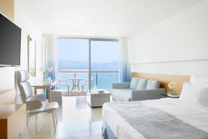 a hotel room with a bed and a living room at Lindos Blu Luxury Hotel-Adults only in Lindos