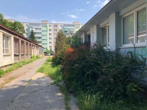 an empty street with bushes next to a building at Moonstreet apartments in Bratislava