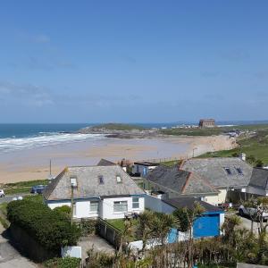 a view of a beach with houses and the ocean at For the Shore, Fistral Beach Newquay - 2 Bed 2 bath - Private Parking with garage for 2 vehicles in Newquay