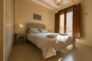 a bedroom with a large bed and a large window at La Caseta de Porrera in Porrera
