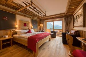 um quarto de hotel com uma cama e uma grande janela em Gröbl-Alm em Mittenwald