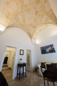 een woonkamer met een stenen plafond en een tafel bij Antico Rifugio in Carovigno