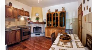 cocina con armarios de madera, mesa y chimenea en Villalbert, en Castel Gandolfo