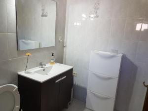 a bathroom with a sink and a white refrigerator at Casa Kiko in Playa de Santiago +20 photos