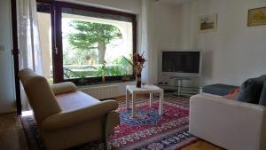 a living room with two chairs and a television at Apartments VUK in Jagodje