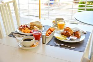 a table with two plates of breakfast foods and a cup of coffee at Bayside Salgados in Albufeira