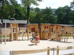 un groupe de structures de jeux en bois dans une aire de jeux dans l'établissement Landidyll, à Breitenbrunn/Erzgeb.