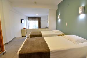 a hotel room with two beds and a window at Bayside Salgados in Albufeira