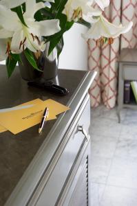 a vase with white flowers on a counter with a yellow paper at Villa Romana Fréjus in Fréjus +59 photos
