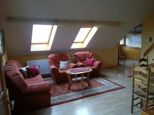a living room with two chairs and a table at Szekszárd Apartman in Szekszárd