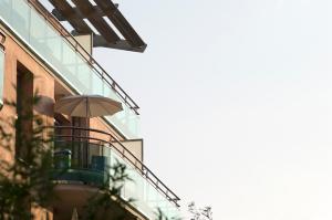 弗雷瑞斯的住宿－Villa Romana Fréjus，一把伞坐在大楼旁的阳台上