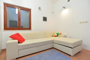 - un canapé blanc dans une chambre avec fenêtre dans l'établissement House Uros 1666, à Ližnjan