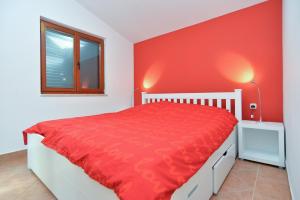 - une chambre rouge avec un lit et une fenêtre dans l'établissement House Uros 1666, à Ližnjan