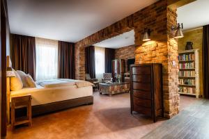 una camera con un grande letto e un muro di mattoni di Penzion BERG a Bratislava