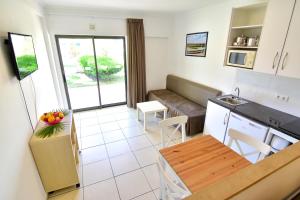 a small kitchen and a living room with a table at Bayside Salgados in Albufeira