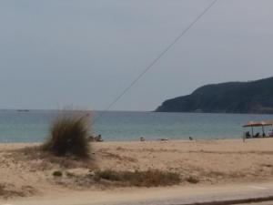 a beach with people in the water and a kite at House Kosmas on the beach in Sarti