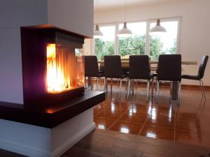 a fireplace in a dining room with a table and chairs at Haus Siggi in Braunlage