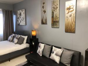 a living room with a couch and paintings on the wall at Centropolis in Manila