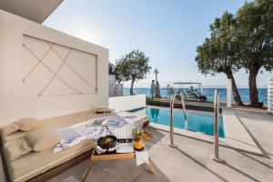 a living room with a pool and a boat on the water at Villa Di Mare Seaside Suites in Ixia