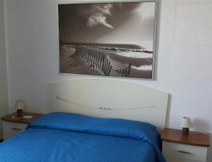 1 dormitorio con 1 cama y una foto en la pared en Appartamento Oasi Calatina, en Caltagirone