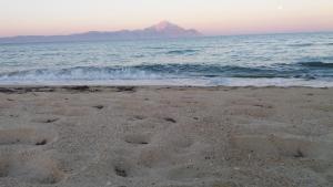 a beach with a mountain in the background and the ocean at House Kosmas on the beach in Sarti
