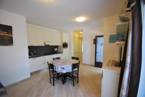 cocina y comedor con mesa y sillas en Appartamenti Acacia e Gardenia en Marina di Campo