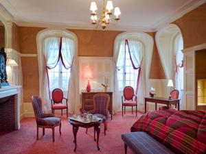 Una sala de estar con una cama, una mesa y sillas. en Château de Beaulieu et Magnolia Spa, The Originals Relais, en Joué-lès-Tours 18 fotos más