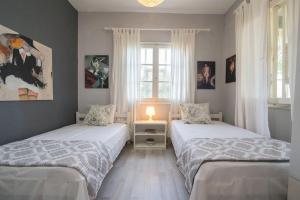 a bedroom with two beds and a window at Seaside Cottage in Paralia Katerinis +52 photos