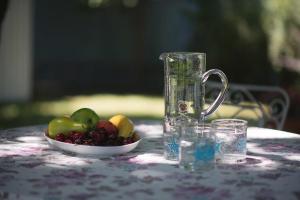 a bowl of fruit on a table with a glass pitcher at Seaside Cottage in Paralia Katerinis