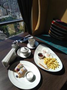 a table with two plates of food and french fries at Zastava Hotel in Voronezh