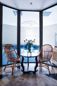 two chairs and a table with a vase of flowers at Raad na Uroczysku in Szklarska Poręba