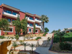 an exterior view of a building with palm trees at Topazio Vibe Beach Hotel & Apartments - Adults Friendly in Albufeira