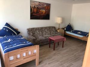 ein Wohnzimmer mit einem Bett und einem Sofa in der Unterkunft Messeapartment Hahnenkamp in Hemmingen