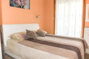 a bedroom with a bed with an orange wall at Apartment Ana in Rovinj