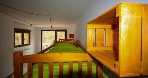 um quarto com um beliche de madeira com lençóis verdes em cabañas bungalow albergue camping valle do seo em Trabadelo