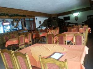 a dining room with tables and chairs and a man in the background at Kanclera Hotel in Kaspichan
