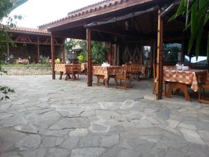 a restaurant with tables and chairs and a pavilion at Kanclera Hotel in Kaspichan