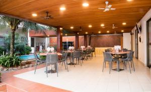 a patio with tables and chairs and a ceiling at Hôtel La Rose Blanche Abidjan in Abidjan