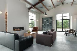 a living room with leather furniture and a fireplace at Camping 7Huizen aan Zee in Scharendijke