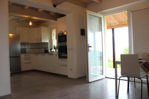 een keuken met witte kasten en een glazen schuifdeur bij Casa Vacanza Alba in Sarzana
