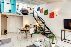 a living room with a table and a spiral staircase at Cocoon'in Cannes Le Suquet in Cannes