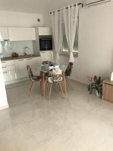 a kitchen with a table and chairs in a room at Sweet Apartments in Split