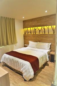 1 dormitorio con 1 cama grande y cabecero de madera en Dahshin Hotel en Taipéi