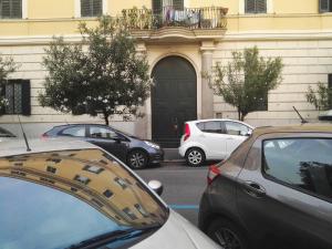 a group of parked cars parked in front of a building at Tolli Colosseo Apartment in Rome