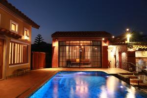 a swimming pool in front of a house at night at Villa Di Montagna at Khaoyai in Pak Chong